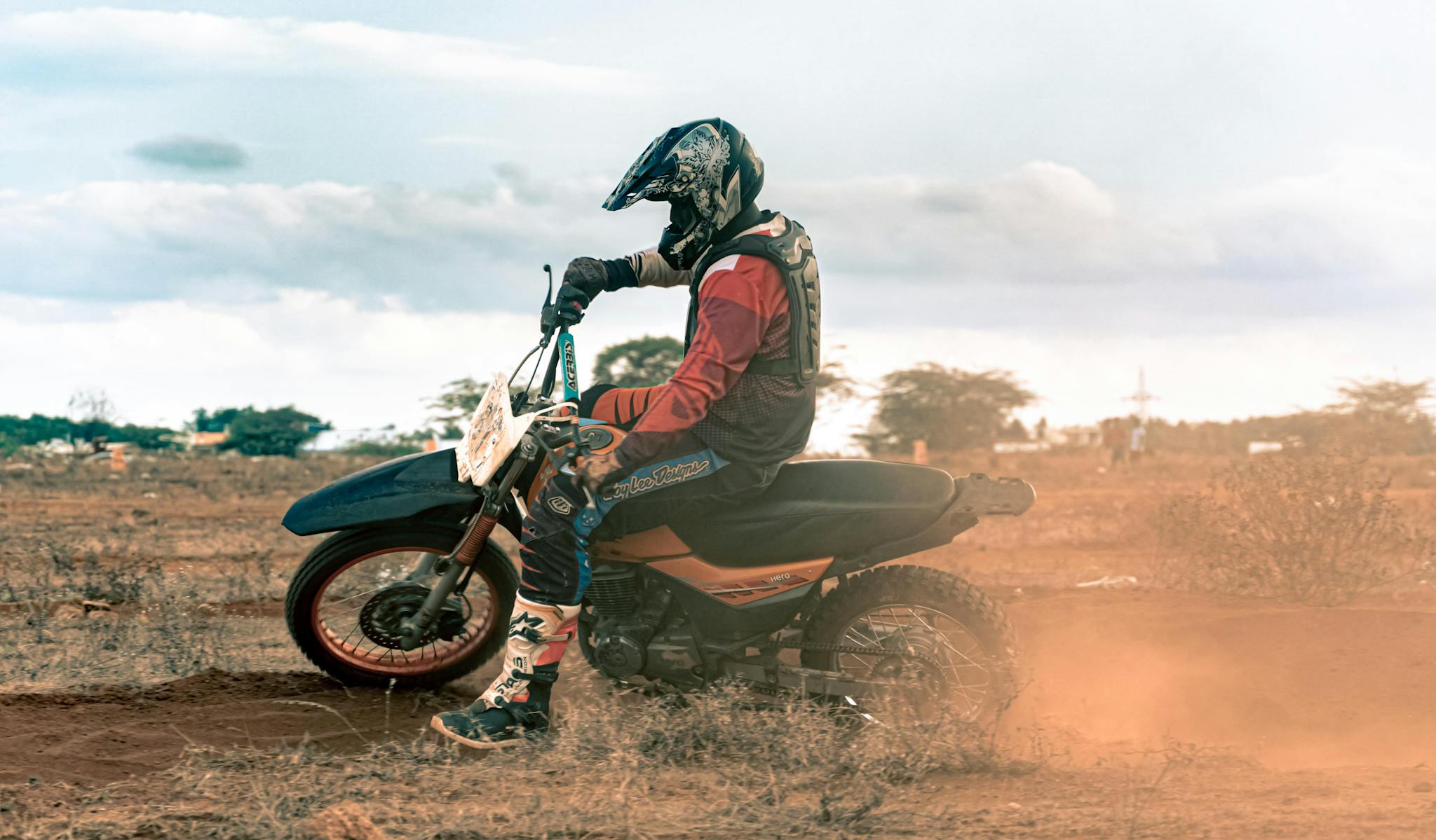 motorcyclist riding a dirt bike on a rugged outdoor trail during the day. 12975100