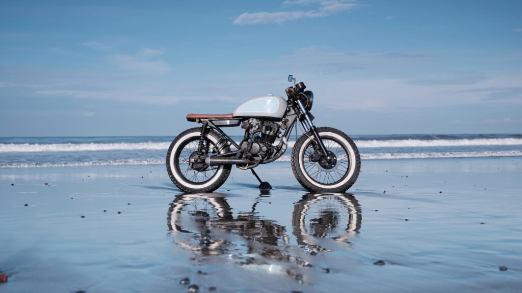 How Motorcycle Brands Can Drive Relevant Website Traffic Effectively 1 Custom vintage motorcycle on a beach, illustrating how motorcycle brands can drive relevant website traffic through compelling imagery