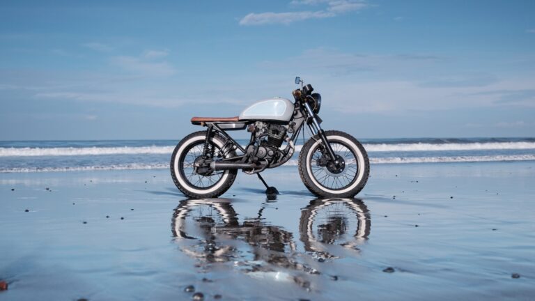 Custom vintage motorcycle on a beach, illustrating how motorcycle brands can drive relevant website traffic through compelling imagery