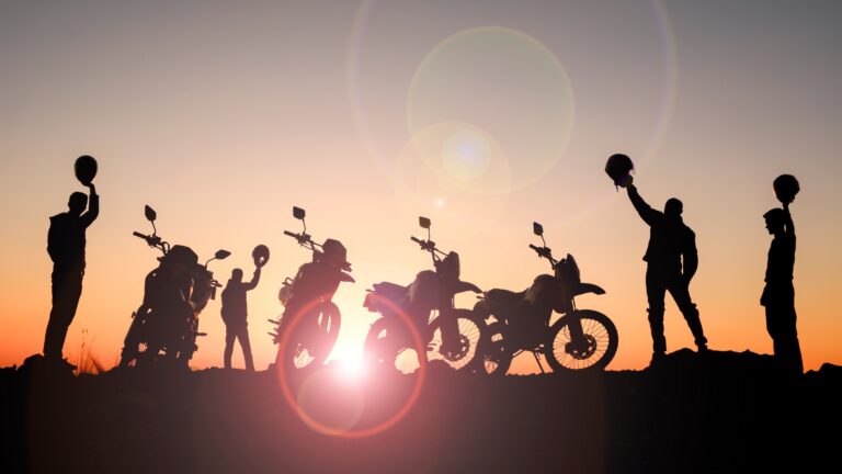 A group of motorcycle riders gathered at a scenic overlook, representing how to build a rider community through shared experiences.